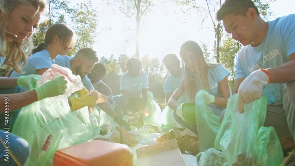 Young multiracial people with a voluntary organization conserving environment. Enthusiastic eco activists of different ages collecting garbage, rubbish. Save the Earth and ecology pollution concept