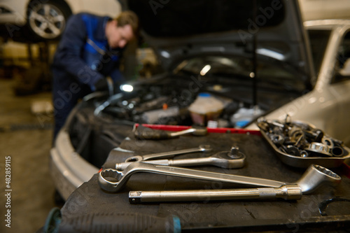 Focus on wrench and professional tools for repairing and inspecting automobiles lying on a desk