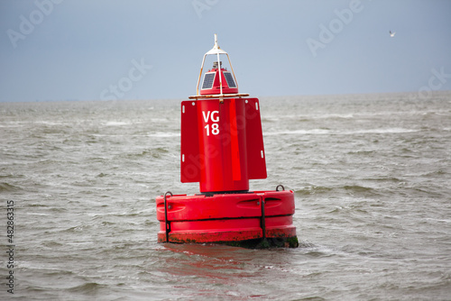 A red channel marker buoy in the water.