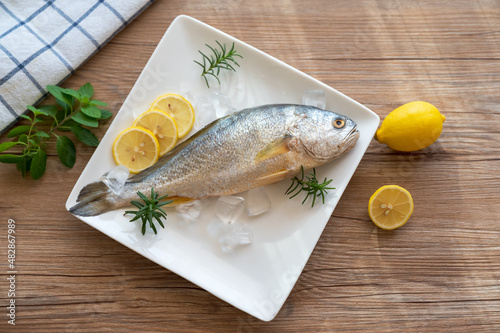 Yellow croaker and lemon on the table photo