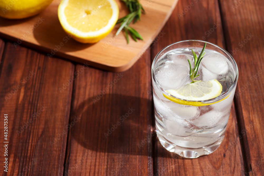 A glass of water with ice, lemon and rosemary. Detox concept or refreshing drinks. Close-up, selective focus A glass of water with ice, lemon and rosemary. Detox concept or refreshing drinks. Close-up, selective focus
