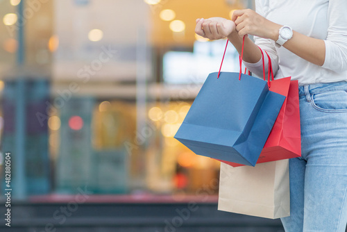 Blurred image, young woman holding a shopping bag after going shopping for discounted items in a department store as the New Year's holiday approaches, there is a promotion on sale. shopping concept