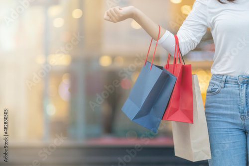 Blurred image, young woman holding a shopping bag after going shopping for discounted items in a department store as the New Year's holiday approaches, there is a promotion on sale. shopping concept