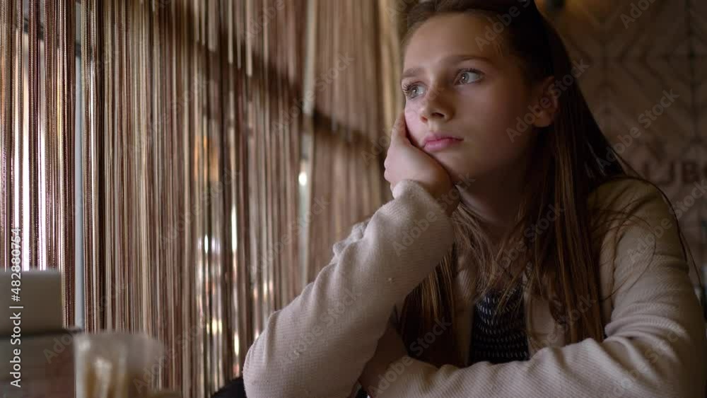 Young woman is sad. She is sitting at the bar waiting for her friend to talk about her problems. She is deciding to leave her boyfriend