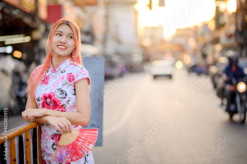 attractive Asian woman wearing traditional cheongsam qipao dress out door , Chinese new year concept