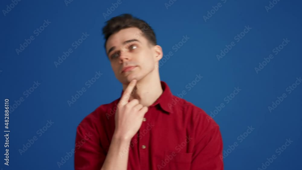 Upset brunet man thinking about something in the blue studio Upset brunet man thinking about something in the blue studio