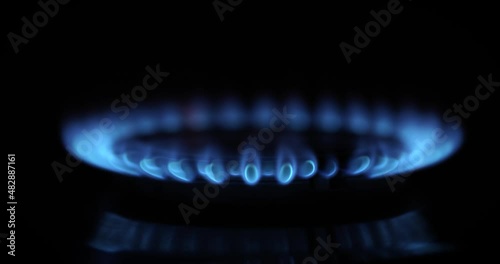 flame ignites on gas stove in dark. slow motion