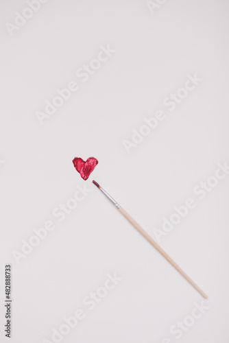 Heart symbol made of red brush strokes on white background. Valentine's Day, Woman Day composition.