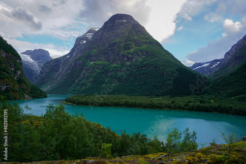 Beautiful Norwegian mountains landscape, in the background the Kjenndal Glacier in Jostedalsbreen National Park. The azure color of the lake's water