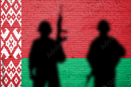 Flag of Belarus painted on a brick wall with soldiers shadows