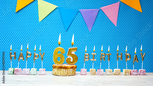 Canvas Print Happy birthday from the letters of candles number 65 on a blue background with polka dots white copy space