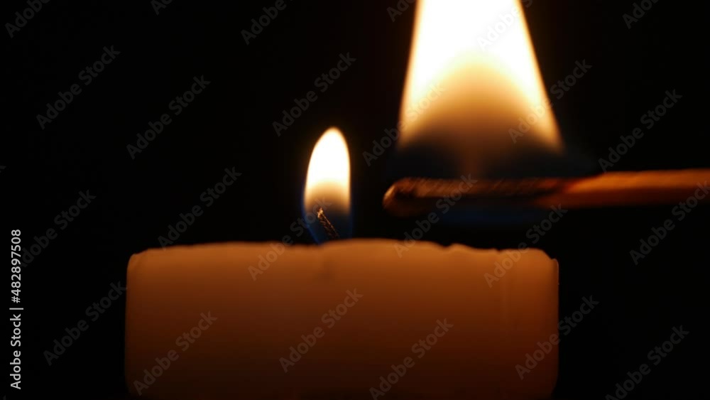 Lighting a Candle with a Fired Match. Man Illuminating with a Candle a Dark Room in Time of an Accidental Power Failure. Lighting a Candle with a Fired Match. Man Illuminating with a Candle a Dark Room in Time of an Accidental Power Failure.