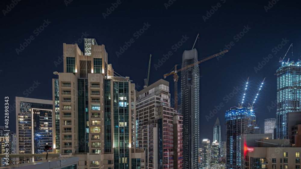 Panorama showing aerial cityscape night timelapse with illuminated architecture of Dubai downtown.