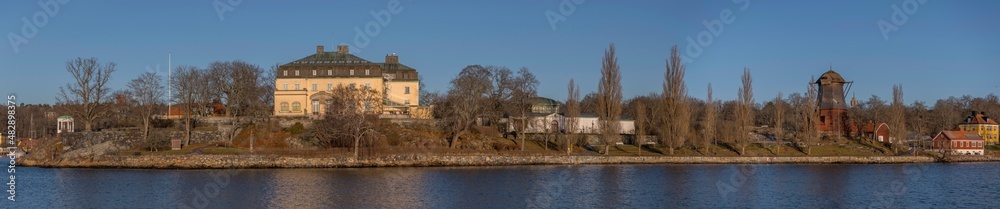 Panorama view of the ness Waldemars Udde, prince Eugens art museum, a gazebo and the old oil mill on the island Djurgården a sunny winter day in the archipelago of Stockholm