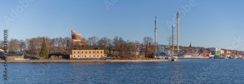Panorama view over the island Kastellholmen with a castell and the skyline of the amusement park towers and the ship yard Beckholmen a sunny winter day in Stockholm