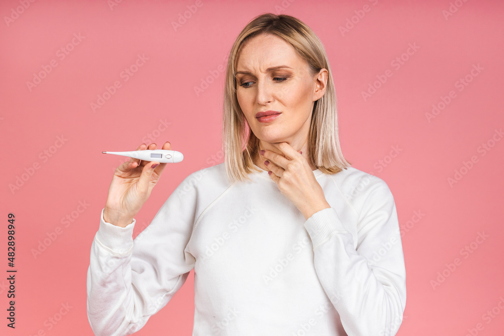 Young woman having flu taking thermometer. Isolated over pink background. Beautiful young woman is sick with a high temperature, a thermometer, isolated close-up. Cold, flu concept. Young woman having flu taking thermometer. Isolated over pink background. Beautiful young woman is sick with a high temperature, a thermometer, isolated close-up. Cold, flu concept.