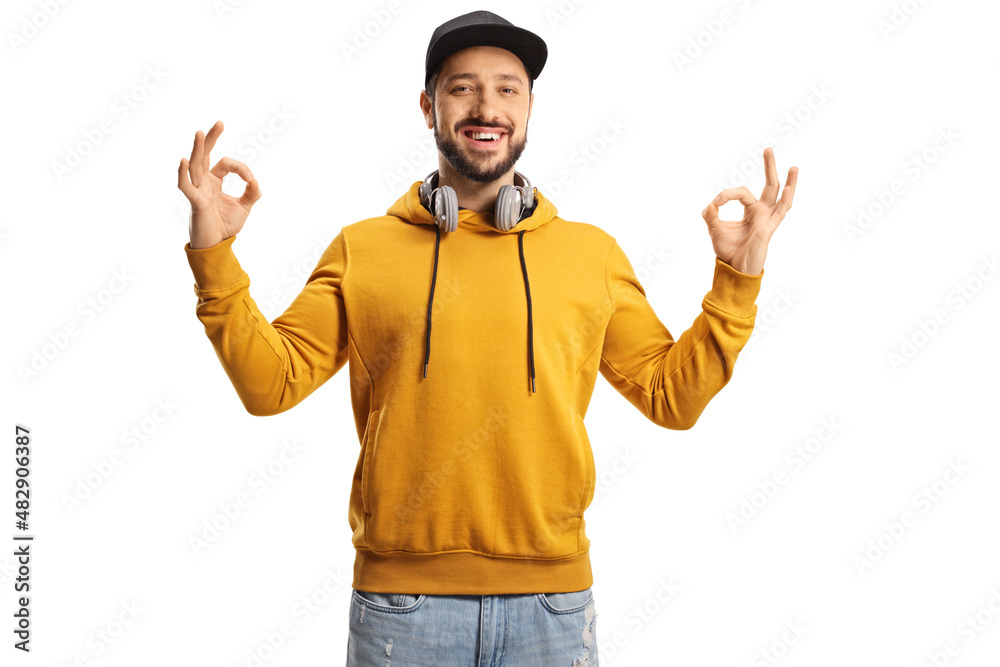 Smiling young man with headphones gesturing ok sign with both hands Smiling young man with headphones gesturing ok sign with both hands