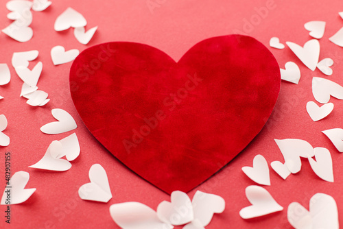 Happy Valentine's Day! Stylish valentine hearts composition on red background. Valentines day card. Cute red velvet heart and little white hearts cut outs on red paper. Love concept