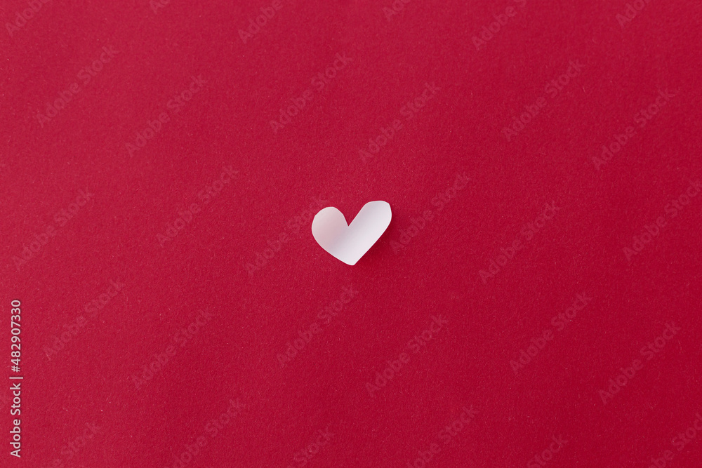 Obraz premium Happy Valentine's Day! Valentine heart flat lay on red background with space for text. Valentines day minimal card. Cute little white heart cut out on red paper. Love concept