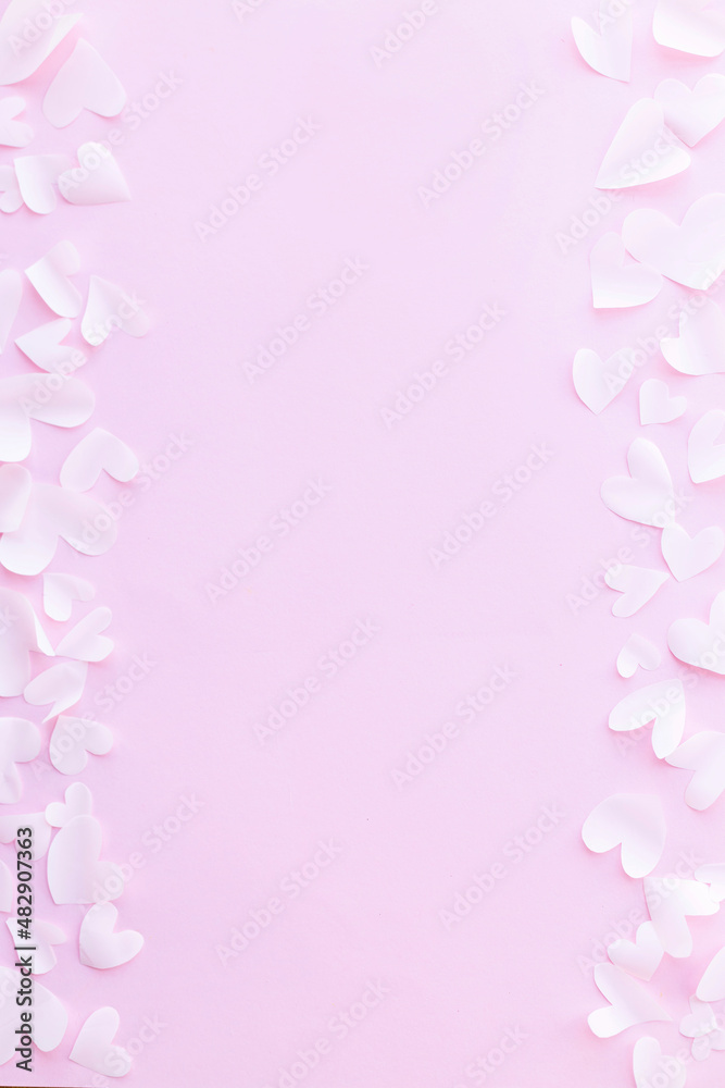 Stylish valentine hearts flat lay on pink background. Happy Valentine's Day! Valentines day card template. Cute little white cutouts hearts frame on pink paper. Love concept