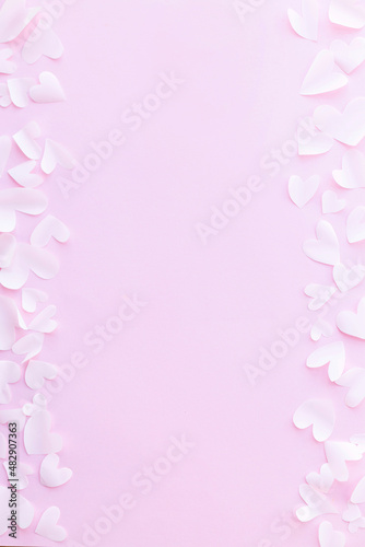 Stylish valentine hearts flat lay on pink background. Happy Valentine's Day! Valentines day card template. Cute little white cutouts hearts frame on pink paper. Love concept