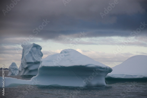 duże góry lodowe o różnych kształtach na morzu w pochmurny dzień
