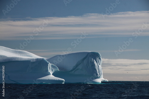 różnokształtne duże góry lodowe na morzu w słoneczny dzień