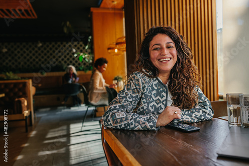 Smiling young adult woman at cafe