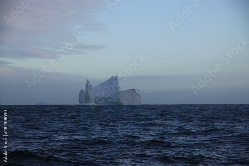 masywne bloki lodowe na morzu o zachodzie słońca