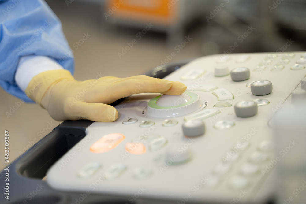 the doctor's hand on the ultrasound machine