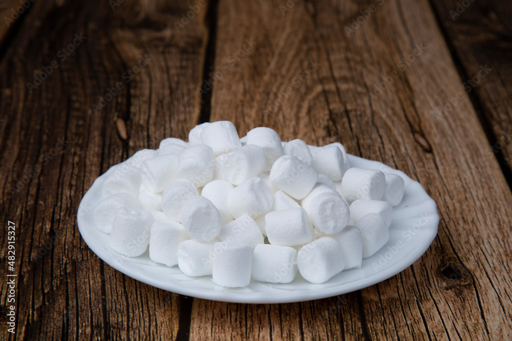 Marshmallows in slices on a wooden background.The dessert is delicious.