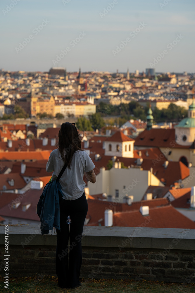 Girl looking over Prague skyline from castle and taking pictures