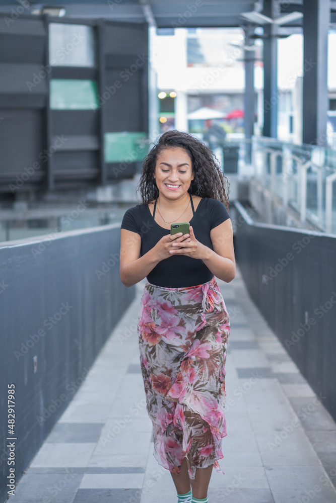 Young woman in the city calling by phone.