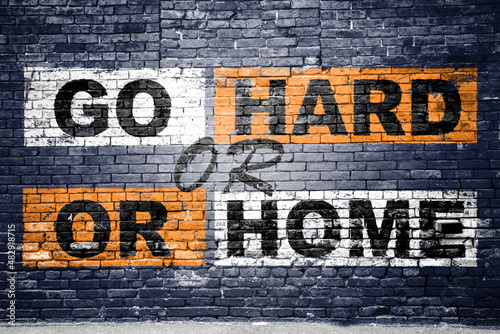 Obraz na plátně Go Hard or Go Home saying lettering Graffiti on Brick Wall