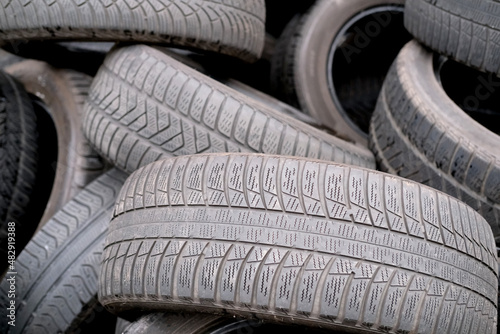 close-up of lot of old rubber car tires with worn treads, the concept of seasonal replacement of rubber tires, traffic safety in ice