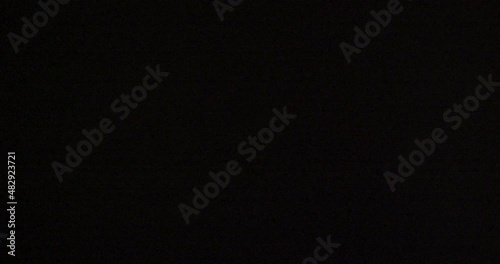 fast camera flashes hitting an super 35 sensor at 60fps, interference noise and artifacts on black background, cool music video overlay or transition in 4K.