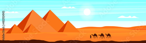 Camel caravan near the pyramids of Egypt. Panoramic landscape. Egyptian pyramids in the desert in the background.