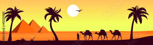 Camel caravan near the pyramids of Egypt. Panoramic landscape. Egyptian pyramids in the desert in the background.