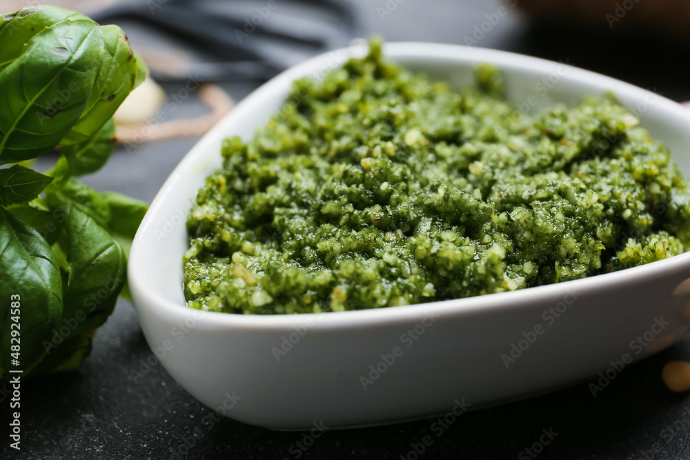 Bowl of tasty pesto sauce on dark background, closeup Bowl of tasty pesto sauce on dark background, closeup