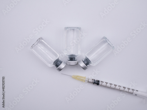 Top view of containers with liquid medicine and syringe isolated on white background