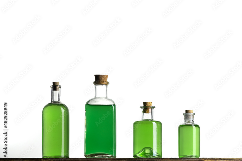 Several glass transparent bottles with cork stopper on a shelf. Vintage glass bottles with  poisons on a white background.