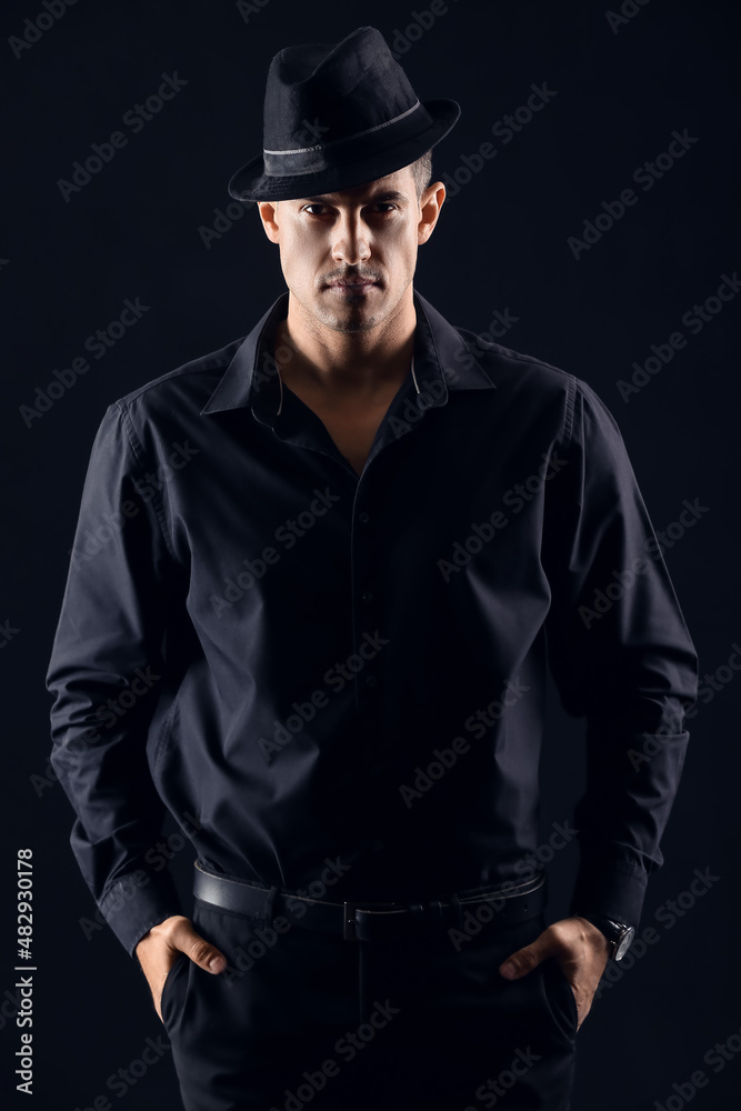 Portrait of fashionable gentleman in stylish hat against dark background Portrait of fashionable gentleman in stylish hat against dark background