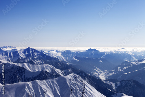 View from off-piste slope on snowy rocks in haze © BSANI