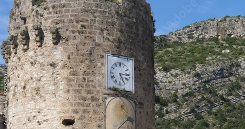 The tower clock at Anduze, Gard, Occitanie, France. The river Gardon in front of the city photo