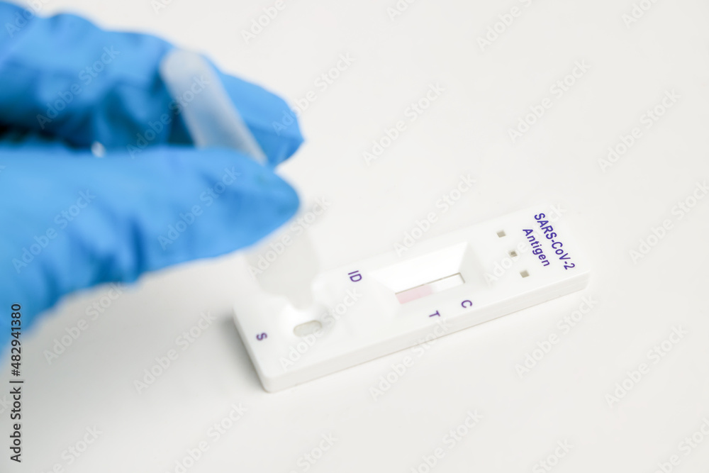 Man makes a covid-19 antigen pcr test macro. The test showed a positive result