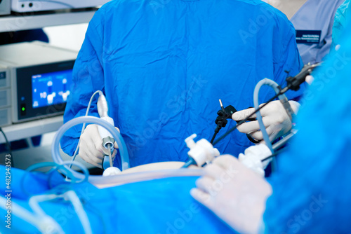 Hands of surgeons with surgical laparoscopic equipment. Selective focus. Surgery of the abdominal cavity. Surgical treatment of proctological diseases. photo