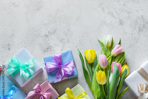 Fototapeta Naklejka Na Ścianę i Meble -  Beautiful tulip flowers and gift boxes for International Women's Day on light background