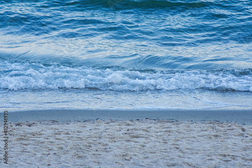 Fototapeta Naklejka Na Ścianę i Meble -  Photo of sandy shore and waves of the blue sea water