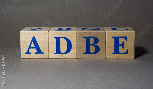 January 19, 2022. New York, USA. Exchange Ticker symbol of Adobe ADBE company, laid out from wooden cubes, on a gray background. photo