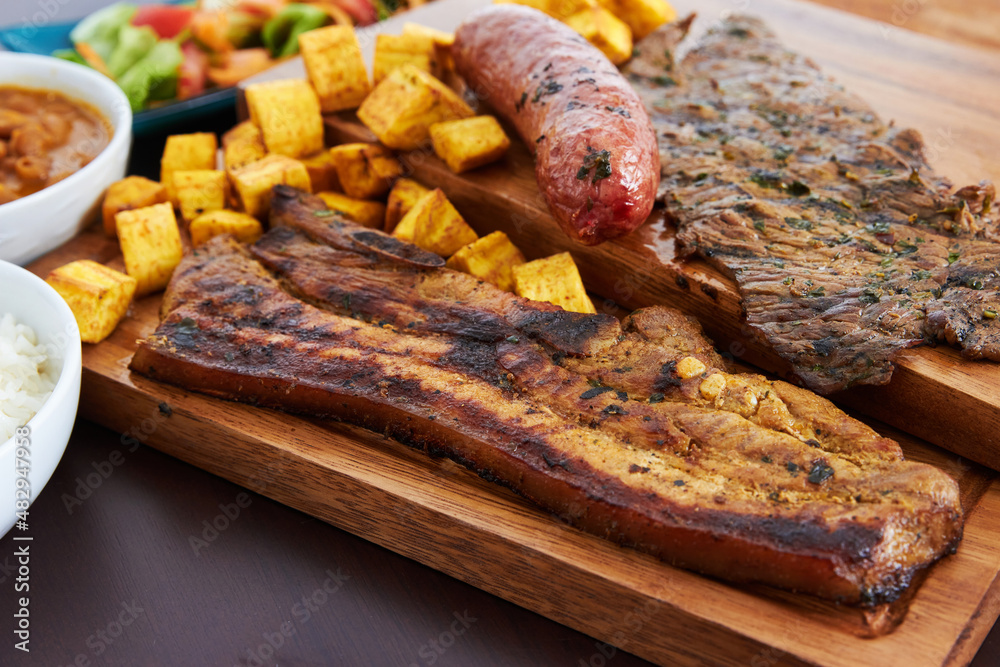 variety of meats with fried plantains and salad variety of meats with fried plantains and salad